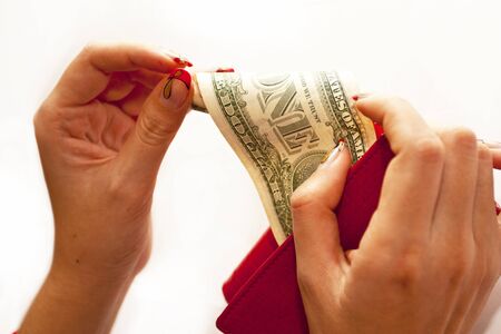 Red purse in hands with dollar on a white backgroundの写真素材