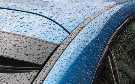 Splashes and water drops on a blue body of the carの写真素材