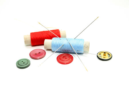 Set of hanks of multi-colored threads and buttons for sewing on a white background