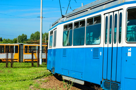 The city blue tram on turn against the blue sky and other tramの写真素材