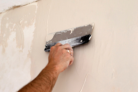 The process of applying the second layer of putty trowel for light plaster wallsの写真素材