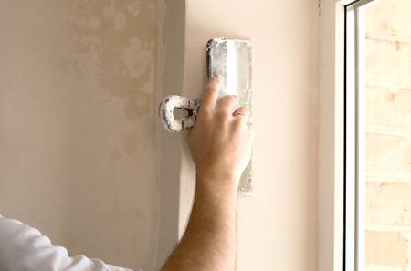 The process of applying the second layer of putty spatula on the sides of the windowの写真素材