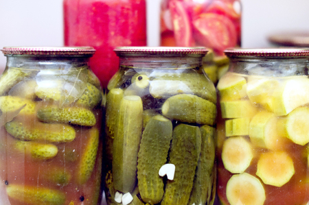 Various canning vegetables in glass jar on a shelf in the pantryの写真素材