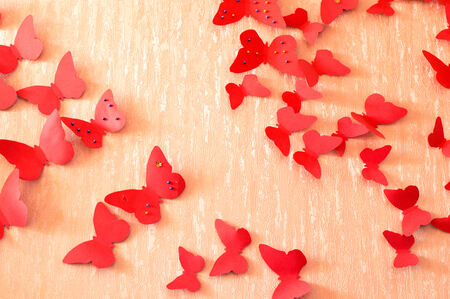 decorative red butterflies from a cardboard on a wall in a roomの写真素材