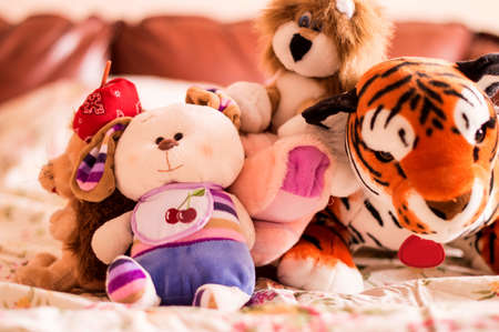 Different soft toys for children on the couch in the bedroomの写真素材