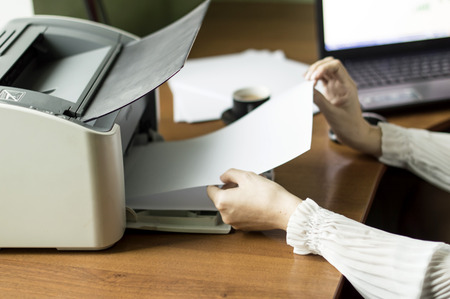 The process of inserting paper in laser printer cartridge on an Office backgroundの写真素材