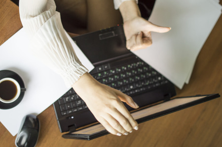 The process of with a laptop and documents on a Office desk with a cup of coffeeの写真素材