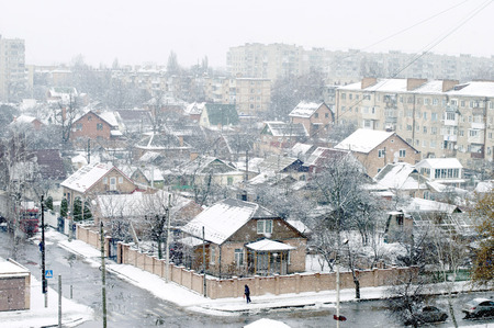 Winter city street with houses covered with white snowの写真素材