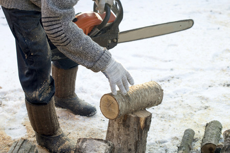 The process of cutting firewood with chainsaw outdoorsの写真素材