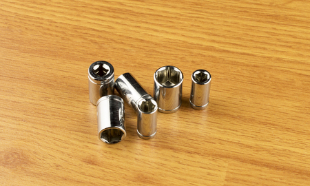 Set of different nozzle to tighten the bolts on the background of the wooden floor