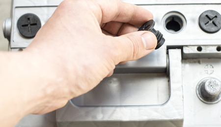The process of unscrewing stoppers in car battery