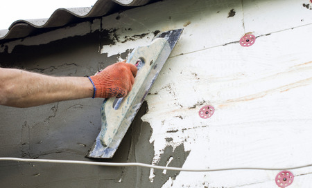 The process of applying putty to the  polyfoam wall using a spatulaの写真素材