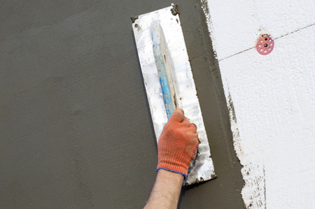 The process of applying putty to the  polyfoam wall using a spatulaの写真素材