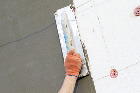 The process of applying putty to the  polyfoam wall using a spatulaの写真素材