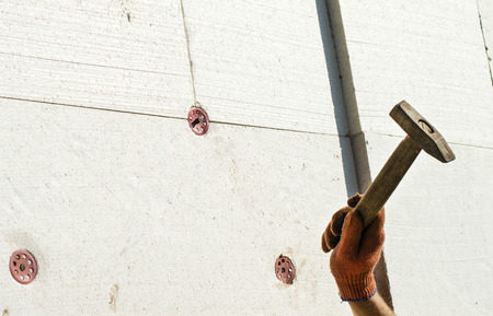 The process of nailing to the wall using a metal hammerの写真素材