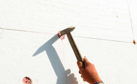 The process of nailing to the wall using a metal hammerの写真素材