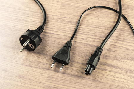Various types of electrical plug on a background of wooden floor in the room