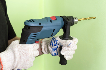 Shock Electric drill  on a background of green wallの写真素材