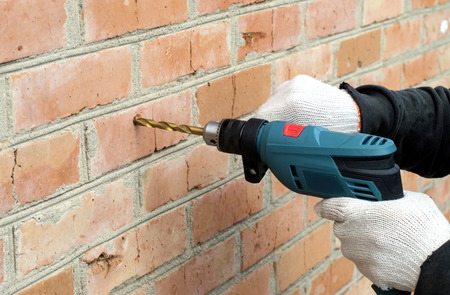 Shock Electric drill against the backdrop of a brick wallの写真素材