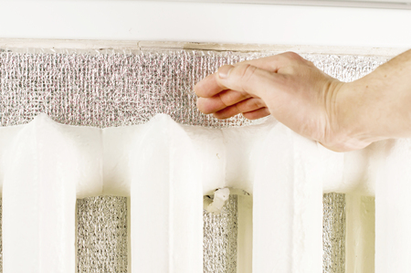 Touching hands to cast iron radiator sectionsの写真素材