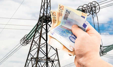 The euro in hand on the background of power lines under the open skyの写真素材