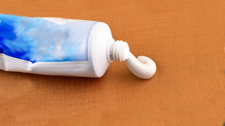 Tube of toothpaste on a brown background