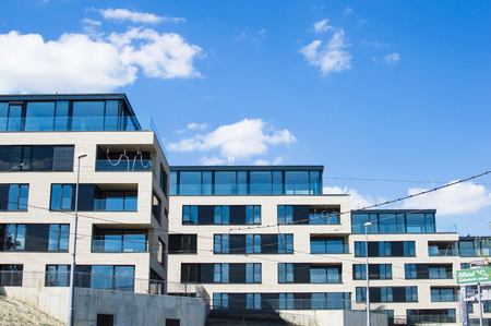 Residential building with glass fence on a background of blue sky with cloudsの写真素材