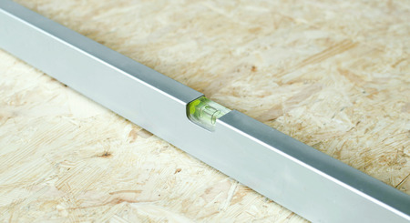 The metal level with on the floor tiles with wood sawdust