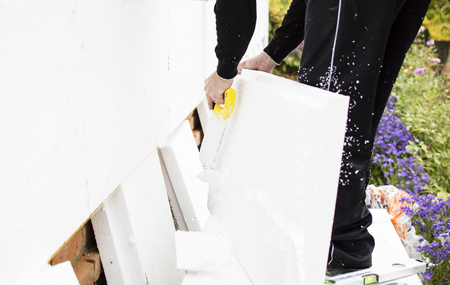 The process of cutting with saws of foam plastic on the background of open spaceの写真素材