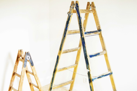 Ladders for painting operations in a room with white wallsの写真素材