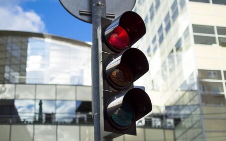 Traffic light activated red light against the  multistory building
