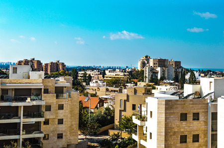 View of city streets on from the roof of of a multistory building on the background of blue skyの写真素材