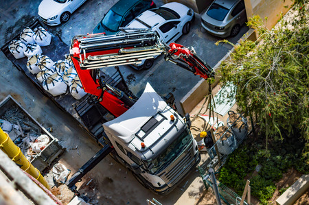 The process of unloading sand bags using the manipulator at the constructionの写真素材