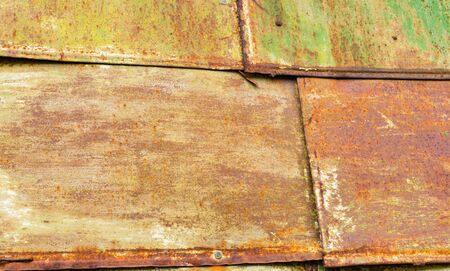 Texture - sheets of rust-colored metal are painted in greenの写真素材