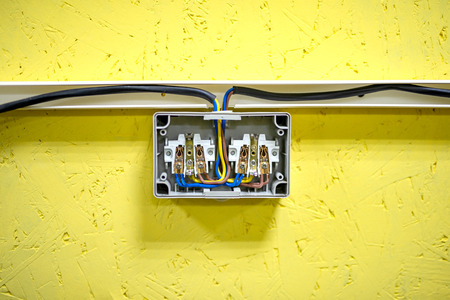 Dual outlet of external type inside - connection of cables on a yellow background