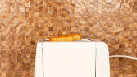 The process of completing the toasting of toasting on the background of a ceramic tile in the...