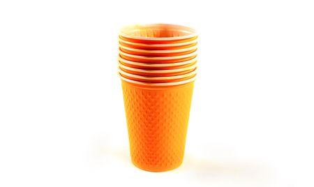 Orange Plastic Cups are stacked one by one on a white backgroundの写真素材