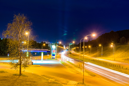 Gas station and autobahn on the outskirts of the city at nightの写真素材