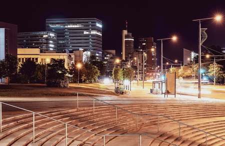 Nightlife of the city streets - office buildings, road asphalt and green parkの写真素材