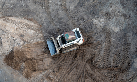 Mini excavator in the unfolding soil - the top viewの写真素材