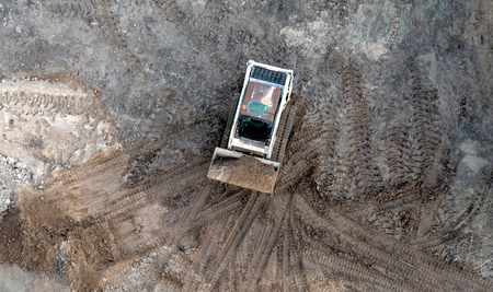 Mini excavator in the unfolding soil - the top view