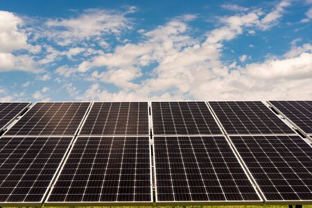 Section sections of solar panels on the background of a blue sky with white cloudsの写真素材