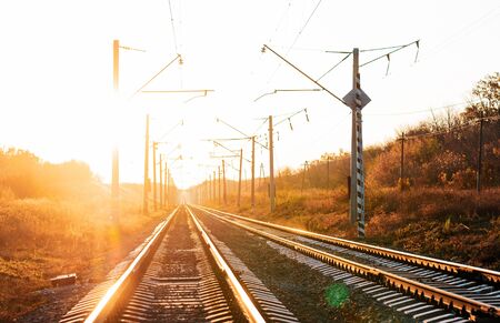 Electrified railway on sunset background in autumn