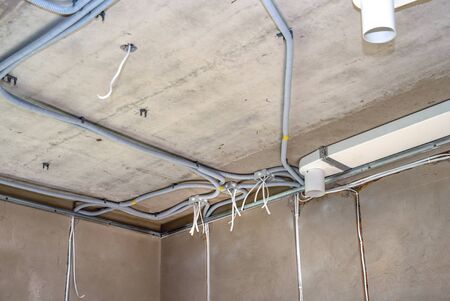 Plastic junction boxes and cable in the corrugation on the concrete ceiling