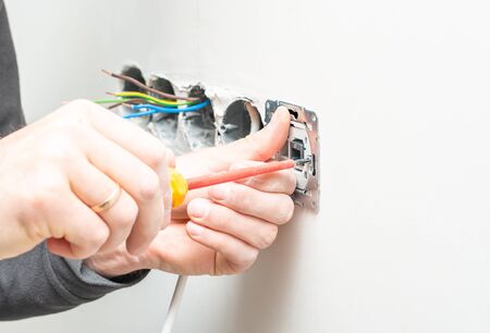 The process of installing an internal socket for Internet access on a background of white gypsum wallの写真素材