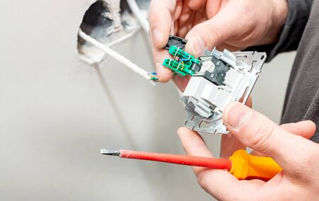 The process of installing an internal socket for Internet access on a background of white gypsum...