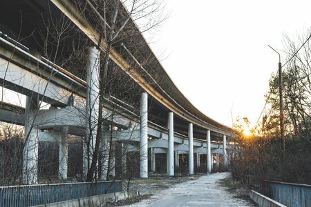 Reinforced concrete bridge view from below on a background of sun raysの写真素材