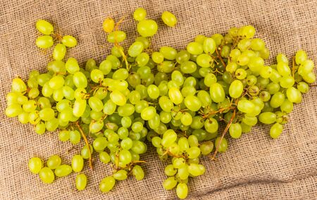 Bunch of green ripe fresh grapes on burlap fabric backgroundの写真素材
