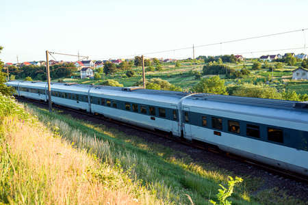 Blurred photo with passing passenger cars at high speed on the background of the settlement