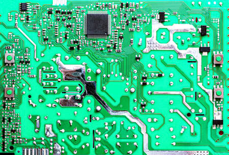 Electronic board in green with various chipsets, transistors and resistors
